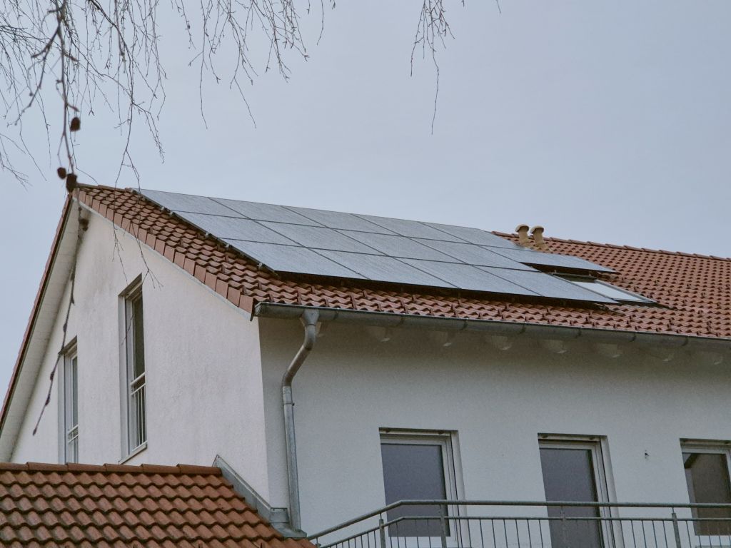 Photovoltaikanlage auf dem roten Ziegeldach eines weißen Wohnhauses – Foto aus der Rezension von Micha D